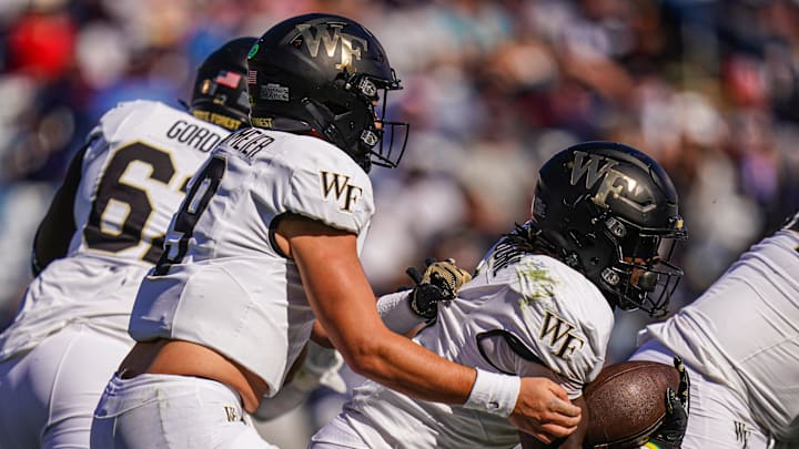 Oct 19, 2024; East Hartford, Connecticut, USA; Wake Forest Demon Deacons quarterback Hank Bachmeier (9) hands off the ball to running back Demond Claiborne (1) against the Connecticut Huskies in the first quarter at Rentschler Field at Pratt & Whitney Stadium. Mandatory Credit: David Butler II-Imagn Images