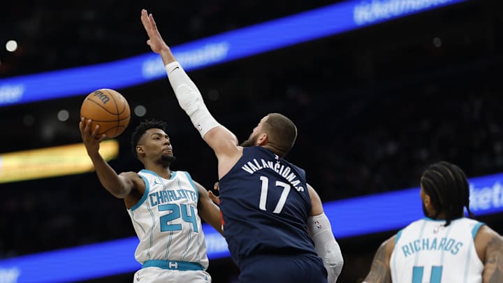 Dec 26, 2024; Washington, District of Columbia, USA; Charlotte Hornets forward Brandon Miller (24) leaps to pass the ball as Washington Wizards center Jonas Valanciunas (17) defends in the first quarter at Capital One Arena. Mandatory Credit: Geoff Burke-Imagn Images