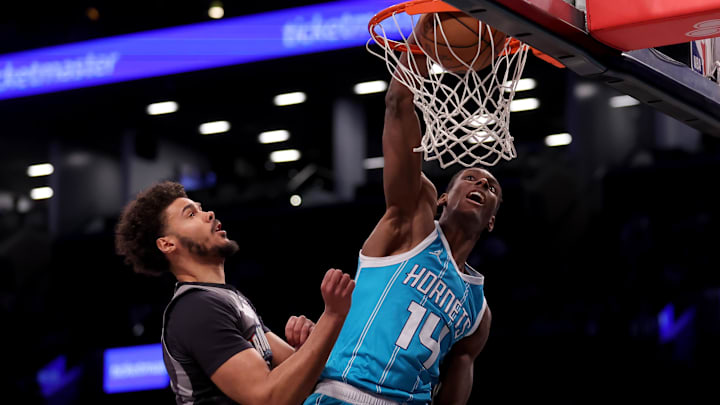 Feb 10, 2025; Brooklyn, New York, USA; Charlotte Hornets forward Moussa Diabate (14) dunks against Brooklyn Nets forward Cameron Johnson (2) during the first quarter at Barclays Center. Mandatory Credit: Brad Penner-Imagn Images