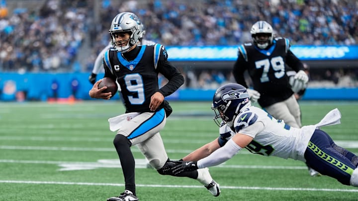 Dec 28, 2025; Charlotte, North Carolina, USA; Carolina Panthers quarterback Bryce Young (9) scores a ten-yard rushing touchdown against Seattle Seahawks safety Ty Okada (39) during the third quarter at Bank of America Stadium. Mandatory Credit: Jim Dedmon-Imagn Images
