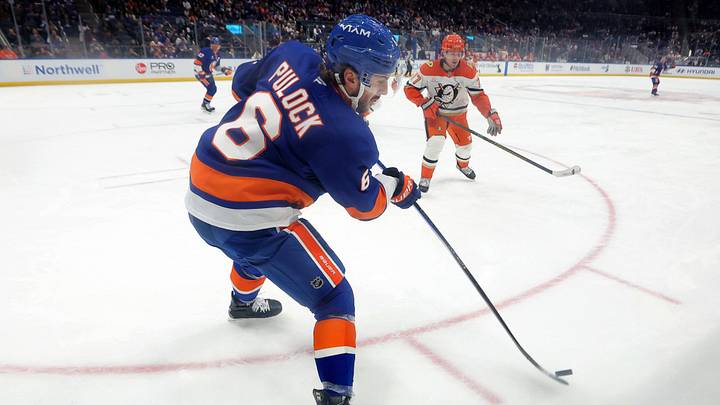 Dec 11, 2025; Elmont, New York, USA; New York Islanders defenseman Ryan Pulock (6) plays the puck against Anaheim Ducks right wing Frank Vatrano (77) during the third period at UBS Arena. Mandatory Credit: Brad Penner-Imagn Images