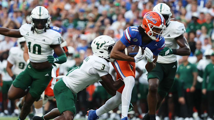 Sep 6, 2025; Gainesville, Florida, USA; Florida Gators wide receiver Aidan Mizell (11) runs with the ball as South Florida Bulls cornerback Jonas Duclona (3) tackles during the second quarter at Ben Hill Griffin Stadium. Mandatory Credit: Kim Klement Neitzel-Imagn Images