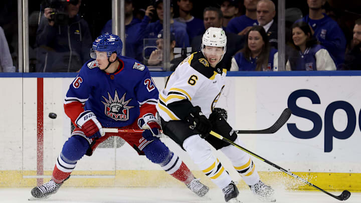 Nov 3, 2022; New York, New York, USA; New York Rangers left wing Jimmy Vesey (26) and Boston Bruins defenseman Mike Reilly (6) fight for the puck during the third period at Madison Square Garden. Mandatory Credit: Brad Penner-Imagn Images