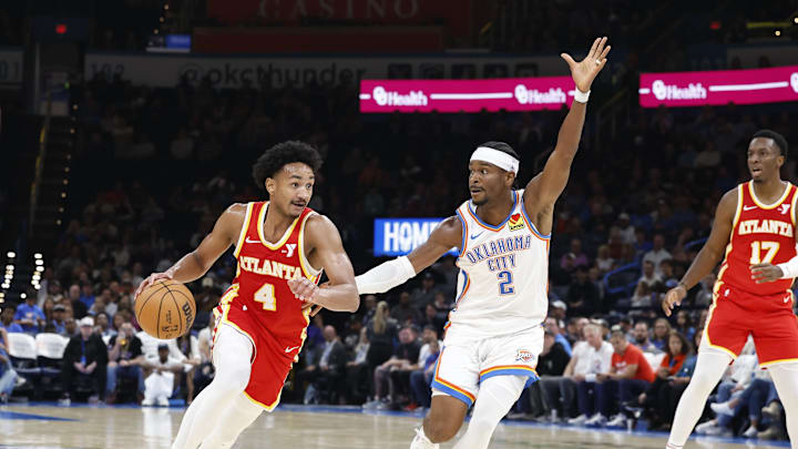 Oct 17, 2024; Oklahoma City, Oklahoma, USA; Atlanta Hawks guard Kobe Bufkin (4) moves the ball down the court as Oklahoma City Thunder guard Shai Gilgeous-Alexander (2) defends during the second quarter at Paycom Center. Mandatory Credit: Alonzo Adams-Imagn Images