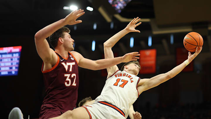 Mar 7, 2026; Charlottesville, Va.; Virginia center Johann Grünloh (17) rebounds the ball over Virginia Tech center Christian Gurdak (32).