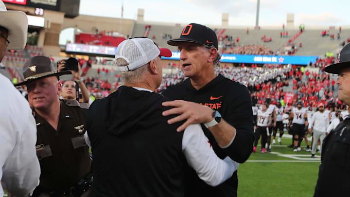 Oct 25, 2025; Lubbock, Texas, USA;  Oklahoma State Cowboys interim head coach Doug Meacham and Texas Tech Red Raiders head coach Joey McGuire meet at mid-field after the game at at Jones AT&T Stadium. Mandatory Credit: Michael C. Johnson-Imagn Images