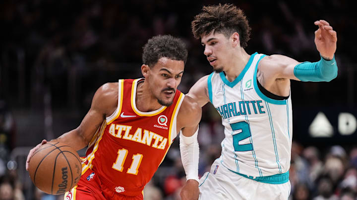 Atlanta Hawks guard Trae Young dribbles the ball against Charlotte Hornets guard LaMelo Ball.