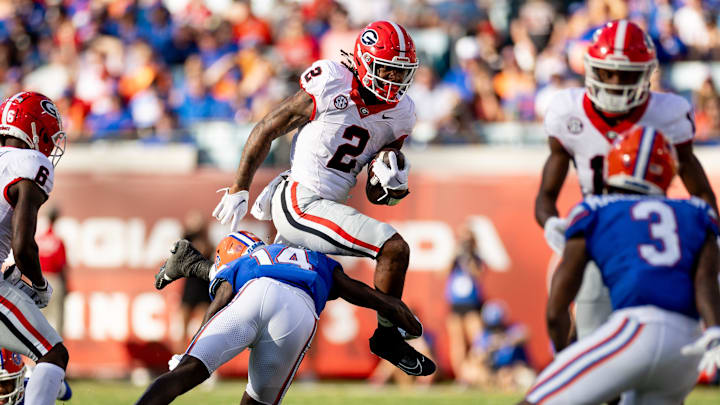 Georgia Bulldogs running back Kendall Milton (2) leaps over Florida Gators safety Jordan Castell (14) during the first half at Everbank Stadium in Jacksonville, FL on Saturday, October 28, 2023. [Matt Pendleton/Gainesville Sun]