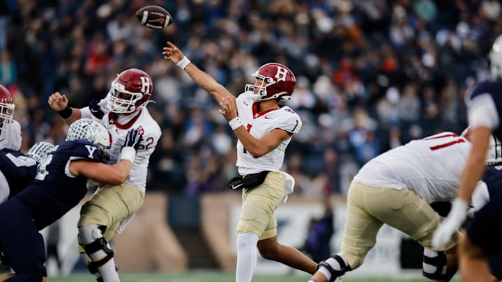 Harvard Crimson quarterback throws a pass against the Yale Bulldogs. Harvard Crimson quarterback throws a pass against the Yale Bulldogs.
