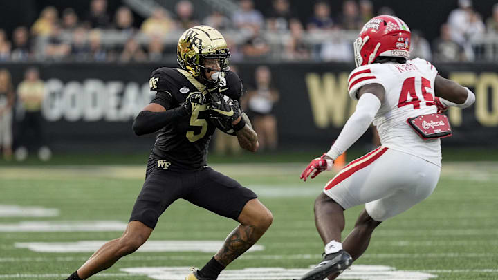 Sep 28, 2024; Winston-Salem, North Carolina, USA;  Wake Forest Demon Deacons wide receiver Horatio Fields (5) tries to get past Louisiana-Lafayette Ragin Cajuns linebacker Caleb Kibodi (45) during the second half at Allegacy Federal Credit Union Stadium. Mandatory Credit: Jim Dedmon-Imagn Images