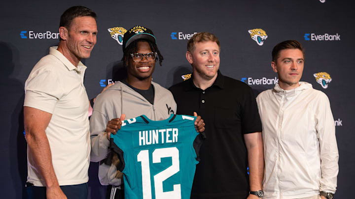 Apr 25, 2025; Jacksonville, FL, USA; Jacksonville Jaguars first round draft pick Travis Hunter poses for a photo with executive vice president of football operations Tony Boselli, head coach Liam Coen, and general manager James Gladstone, during a press conference at Miller Electric Center. Mandatory Credit: Travis Register-Imagn Images