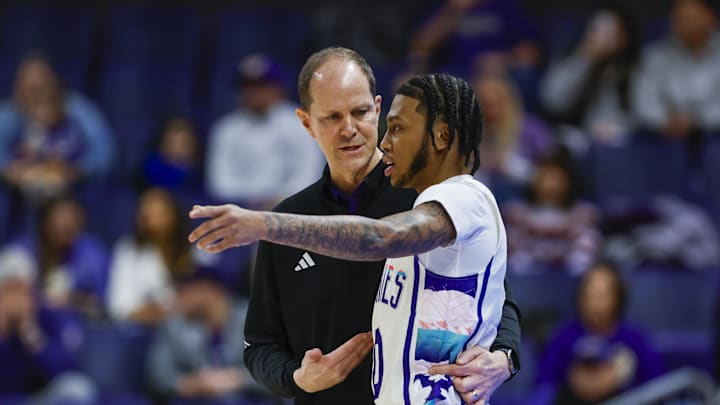 Huskies head coach Mike Hopkins talks with guard Koren Johnson (0) during a game against California in 2024.