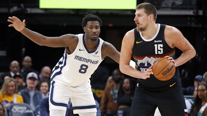 Nov 24, 2025; Memphis, Tennessee, USA; Denver Nuggets center Nikola Jokic (15) handles the ball as Memphis Grizzlies forward/center Jaren Jackson Jr. (8) defends during the fourth quarter at FedExForum. Mandatory Credit: Petre Thomas-Imagn Images