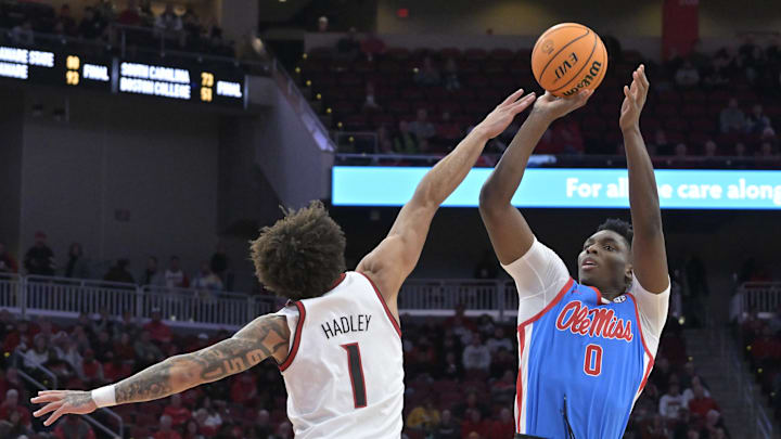 Dec 3, 2024; Louisville, Kentucky, USA; Mississippi Rebels forward Malik Dia (0) shoots against Louisville Cardinals guard J'Vonne Hadley (1) during the first half at KFC Yum! Center. Mandatory Credit: Jamie Rhodes-Imagn Images Dec 3, 2024; Louisville, Kentucky, USA; Mississippi Rebels forward Malik Dia (0) shoots against Louisville Cardinals guard J'Vonne Hadley (1) during the first half at KFC Yum! Center. Mandatory Credit: Jamie Rhodes-Imagn Images