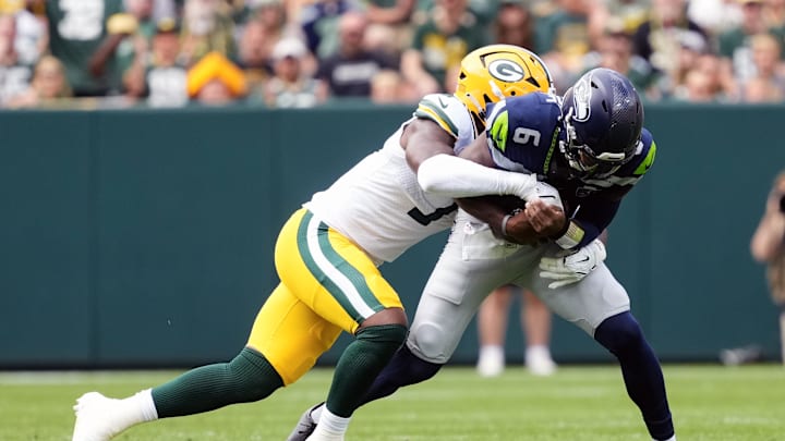 Aug 23, 2025; Green Bay, Wisconsin, USA;  Seattle Seahawks quarterback Jalen Milroe (6) is tackled by Green Bay Packers linebacker Quay Walker (7) during the first quarter at Lambeau Field. Mandatory Credit: Jeff Hanisch-Imagn Images