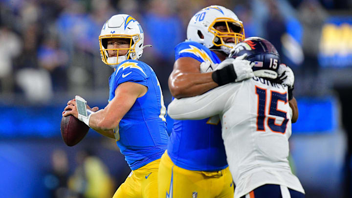 Dec 19, 2024; Inglewood, California, USA; Los Angeles Chargers quarterback Justin Herbert (10) drops back to pass as offensive tackle Rashawn Slater (70) provides coverage against Denver Broncos linebacker Nik Bonitto (15) during the second half at SoFi Stadium. 