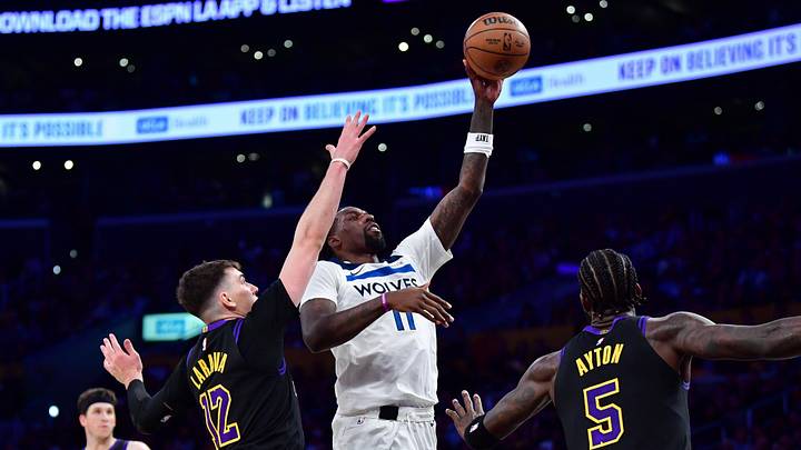 Mar 10, 2026; Los Angeles, California, USA; Minnesota Timberwolves center Naz Reid (11) shoots against Los Angeles Lakers forward Jake LaRavia (12) and center Deandre Ayton (5) during the second half at Crypto.com Arena. Mandatory Credit: Gary A. Vasquez-Imagn Images