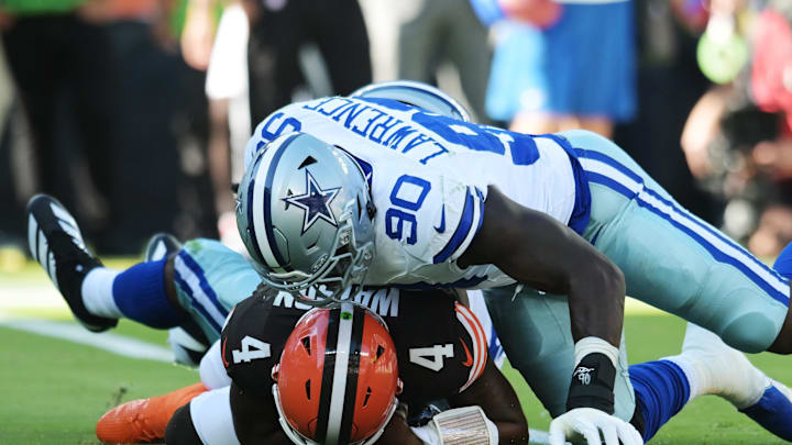 Sep 8, 2024; Cleveland, Ohio, USA; Dallas Cowboys defensive end DeMarcus Lawrence (90) lies on top of Cleveland Browns quarterback Deshaun Watson (4) after a sack during the first quarter at Huntington Bank Field. Mandatory Credit: Ken Blaze-Imagn Images