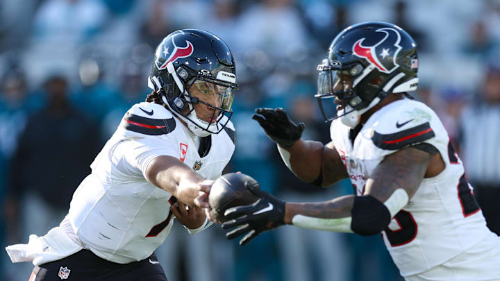 Dec 1, 2024; Jacksonville, Florida, USA; Houston Texans quarterback C.J. Stroud (7) hands off to running back Joe Mixon (28) in the fourth quarter at EverBank Stadium. Mandatory Credit: Nathan Ray Seebeck-Imagn Images