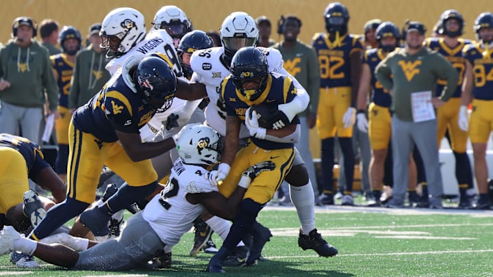 West Virginia University running back Diore Hubbard dragging the Colorado defense.