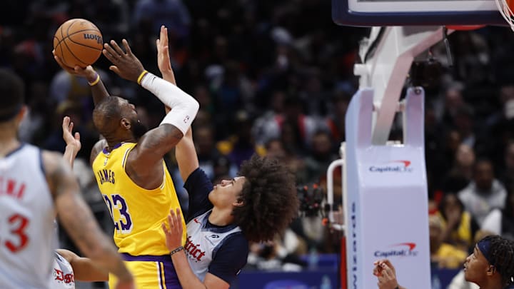 Jan 30, 2025; Washington, District of Columbia, USA; Los Angeles Lakers forward LeBron James (23) is fouled by Washington Wizards forward Kyshawn George (18) while scoring in the third quarter at Capital One Arena. Mandatory Credit: Geoff Burke-Imagn Images