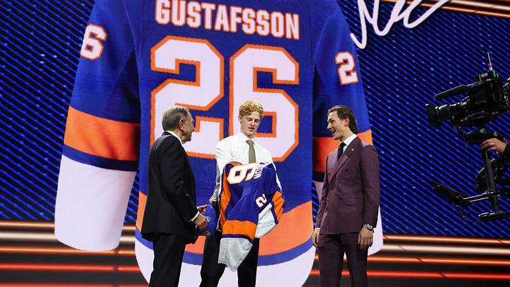 Jun 26, 2026; Buffalo, New York, USA; Malte Gustafsson reacts beside NHL commissioner Gary Bettman and New York Islanders player Matthew Schaefer after being selected with the thirteenth pick in the first round of the 2026 NHL Draft by the Islanders at KeyBank Center. Mandatory Credit: Timothy T. Ludwig-Imagn Images