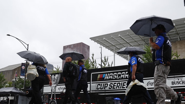 Jul 2, 2023; Chicago, Illinois, USA; Crew members walk in heavy rain along Grant Park to resume the start of The Loop 121 of the Chicago Street Race. Jul 2, 2023; Chicago, Illinois, USA; Crew members walk in heavy rain along Grant Park to resume the start of The Loop 121 of the Chicago Street Race.