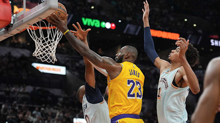 Nov 27, 2024; San Antonio, Texas, USA;  Los Angeles Lakers forward LeBron James (23) shoots between San Antonio Spurs forward Keldon Johnson (0) and center Victor Wembanyama (1) in the second half at Frost Bank Center. Mandatory Credit: Daniel Dunn-Imagn Images