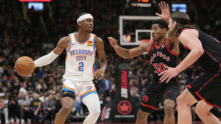 Mar 22, 2024; Toronto, Ontario, CAN; Oklahoma City Thunder guard Shai Gilgeous-Alexander (2) looks to make a play against Toronto Raptors guard Ochai Agbaji (30) and  forward Kelly Olynyk (41) during the first half at Scotiabank Arena. Mandatory Credit: John E. Sokolowski-Imagn Images