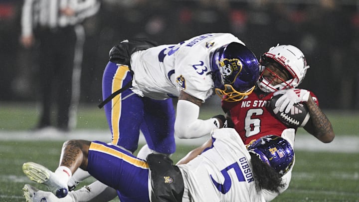 North Carolina State Wolfpack wide receiver Wesley Grimes (6) is hit by East Carolina Pirates linebacker Dameon Wilson (23).