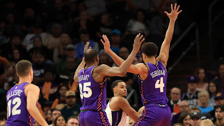 Mar 14, 2025; Phoenix, Arizona, USA; Phoenix Suns forward Kevin Durant (35) and center Oso Ighodaro (4) play defense on Sacramento Kings forward Keegan Murray (13) during the first half at Footprint Center. Mandatory Credit: Mark J. Rebilas-Imagn Images