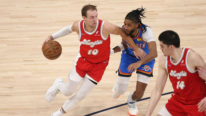 Apr 26, 2025; Memphis, Tennessee, USA; Memphis Grizzlies guard Luke Kennard (10) dribbles as Oklahoma City Thunder guard Isaiah Joe (11) defends during the second quarter during game four for the first round of the 2024 NBA Playoffs at FedExForum. Mandatory Credit: Petre Thomas-Imagn Images