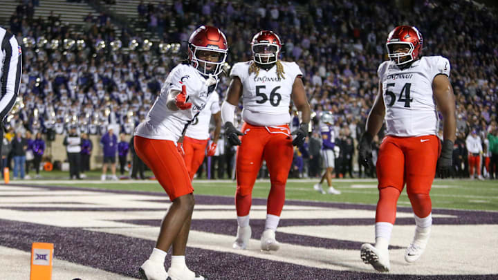 Nov 23, 2024; Manhattan, Kansas, USA; Cincinnati Bearcats wide receiver Tony Johnson (0) celebrates a touchdown in the third quarter against the Kansas State Wildcats at Bill Snyder Family Football Stadium. Mandatory Credit: Scott Sewell-Imagn Images Nov 23, 2024; Manhattan, Kansas, USA; Cincinnati Bearcats wide receiver Tony Johnson (0) celebrates a touchdown in the third quarter against the Kansas State Wildcats at Bill Snyder Family Football Stadium. Mandatory Credit: Scott Sewell-Imagn Images