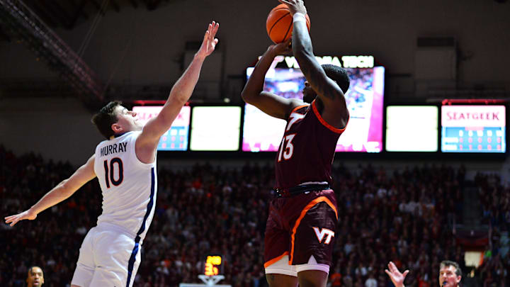Feb 19, 2024; Blacksburg, Virginia, USA; Virginia Tech Hokies guard Jaydon Young (13) shoots a three point shot as Virginia Cavaliers guard Taine Murray (10) defends during the second half at Cassell Coliseum. Mandatory Credit: Brian Bishop-Imagn Images