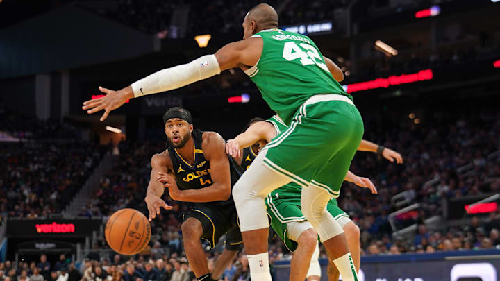 Jan 20, 2025; San Francisco, California, USA; Golden State Warriors guard Moses Moody (4) passes the ball around the reach of Boston Celtics center Al Horford (42) in the third quarter at the Chase Center. Mandatory Credit: Cary Edmondson-Imagn Images