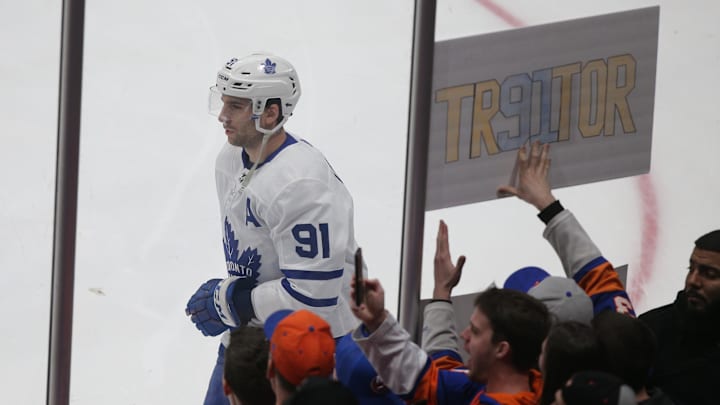 Feb 28, 2019; Brooklyn, NY, USA; Toronto Maple Leafs center John Tavares (91) skates past a sign held by a fan of the New York Islanders during warm ups before a game at the Nassau Veterans Memorial Coliseum. Mandatory Credit: Brad Penner-Imagn Images