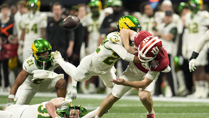Jan 9, 2026; Atlanta, GA, USA; Oregon Ducks defensive back Jadon Canady (22) forces Indiana Hoosiers quarterback Fernando Mendoza (15) to fumble during the third quarter of the 2025 Peach Bowl and semifinal game of the College Football Playoff at Mercedes-Benz Stadium. Mandatory Credit: Dale Zanine-Imagn Images