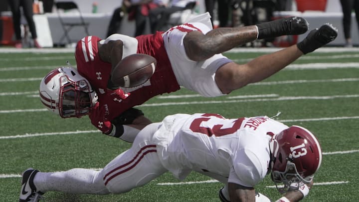 Sep 14, 2024; Madison, Wisconsin, USA; Wisconsin Bulldogs running back Chez Mellusi (1) fumbles the ball after being hit by Alabama Crimson Tide defensive back Malachi Moore (13) during the second quarter at Camp Randall Stadium. Alabama recovered the ball. Mandatory Credit: Mark Hoffman/USA TODAY Network via Imagn Images