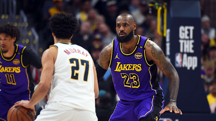Feb 22, 2025; Denver, Colorado, USA; Los Angeles Lakers forward LeBron James (23) defends Denver Nuggets guard Jamal Murray (27) during the second half at Ball Arena. Mandatory Credit: Christopher Hanewinckel-Imagn Images
