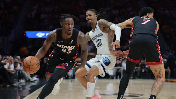 Apr 3, 2025; Miami, Florida, USA; Miami Heat guard Davion Mitchell (45) drives to the basket past Memphis Grizzlies guard Ja Morant (12) during the fourth quarter at Kaseya Center. Mandatory Credit: Sam Navarro-Imagn Images
