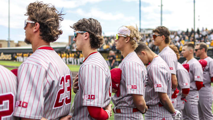 Indiana baseball players stand for the National Anthem during a game at Iowa in April. Big Ten logos feature prominently on their sleeves.