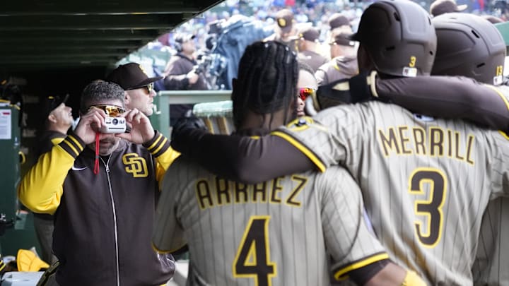 Apr 6, 2025; Chicago, Illinois, USA; San Diego Padres coach Nick Punto takes a Polaroid photo of outfielder Jackson Merrill (3) and  first base Luis Arraez (4) after Merrill hit a two-run home run against the Chicago Cubs during the fourth inning at Wrigley Field. Mandatory Credit: David Banks-Imagn Images