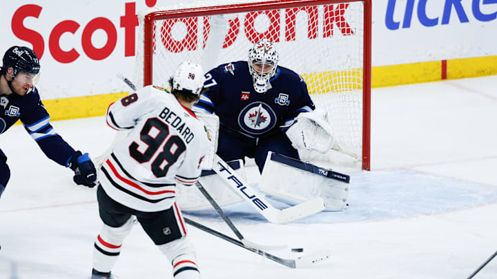 Mar 3, 2026; Winnipeg, Manitoba, CAN;  Winnipeg Jets goalie Connor Hellebuyck (37) makes a save against Chicago Blackhawks forward Connor Bedard (98) during the second period at Canada Life Centre. Mandatory Credit: Terrence Lee-Imagn Images