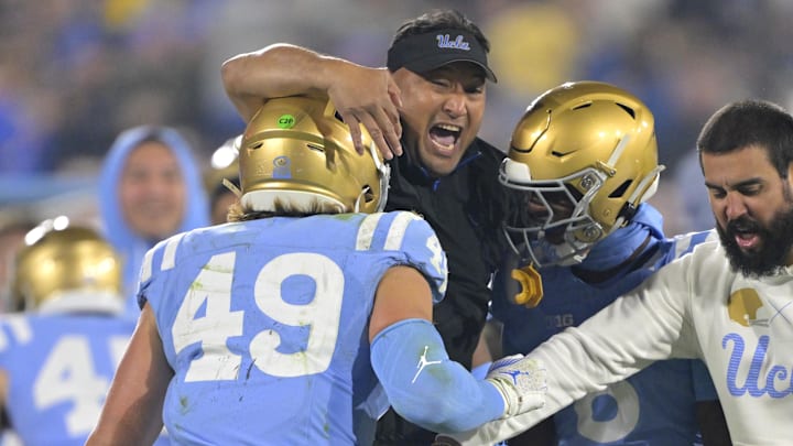 Nov 8, 2024; Pasadena, California, USA;   UCLA Bruins defensive coordinator Ikaika Malloe, center, celebrates with linebacker Carson Schwesinger (49) defensive back Jaylin Davies (6) after an interception in the second half against the Iowa Hawkeyes at the Rose Bowl. Mandatory Credit: Jayne Kamin-Oncea-Imagn Images