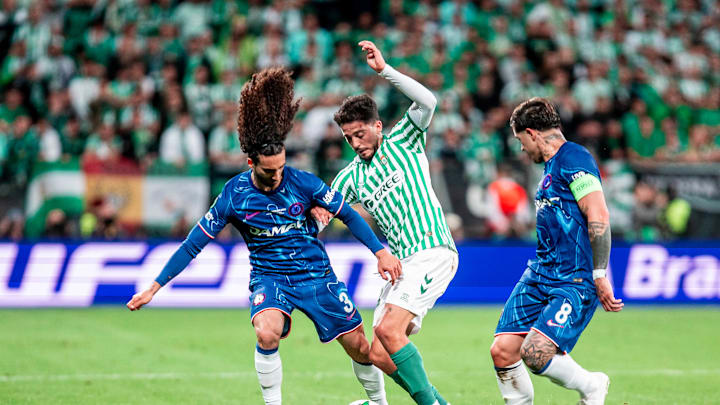 USMNT midfielder Johnny Cardoso being surrounded by two Chelsea players while playing for Real Betis in the 2025 UEFA Conference League Final.