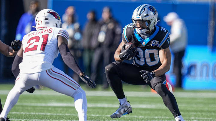 Dec 22, 2024; Charlotte, North Carolina, USA; Carolina Panthers running back Chuba Hubbard (30) tries to elude Arizona Cardinals cornerback Garrett Williams (21) during the first quarter at Bank of America Stadium. Mandatory Credit: Jim Dedmon-Imagn Images