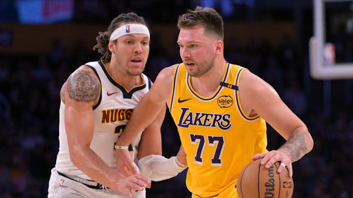Mar 19, 2025; Los Angeles, California, USA;  Los Angeles Lakers guard Luka Doncic (77) is guarded by Denver Nuggets forward Aaron Gordon (32) in the first half at Crypto.com Arena. Mandatory Credit: Jayne Kamin-Oncea-Imagn Images