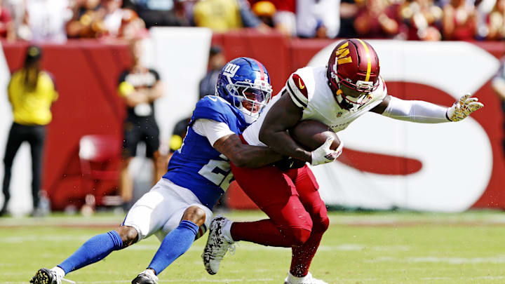 Washington Commanders wide receiver Deebo Samuel is tackled by New York Giants cornerback Dru Phillips.