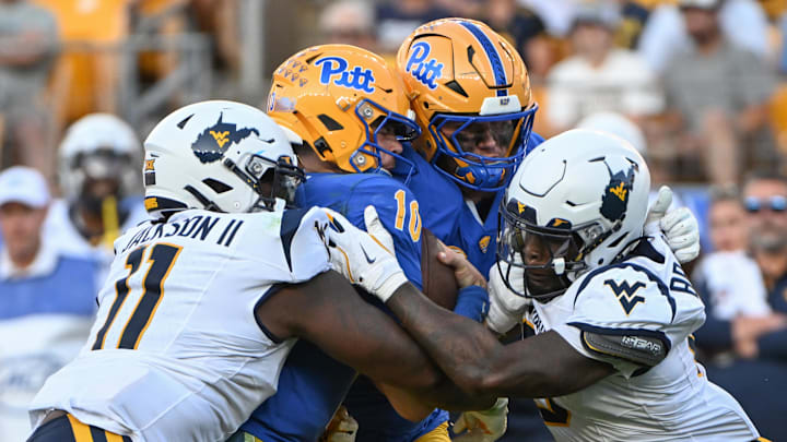 Sep 14, 2024; Pittsburgh, Pennsylvania, USA; West Virginia Mountaineers defenders T.J. Jackson (11) and  Tyrin Bradley Jr. (8) sack Pittsburgh Panthers quarterback Eli Holstein (10) during the fourth quarter at Acrisure Stadium. Mandatory Credit: Barry Reeger-Imagn Images