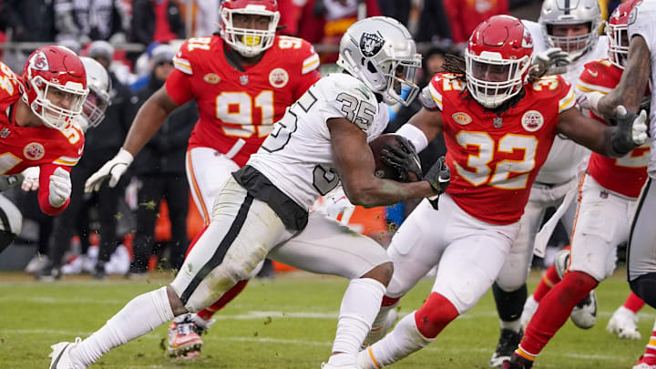 Dec 25, 2023; Kansas City, Missouri, USA; Las Vegas Raiders running back Zamir White (35) runs the ball as Kansas City Chiefs linebacker Nick Bolton (32) attempts the tackle during the second half at GEHA Field at Arrowhead Stadium. Mandatory Credit: Denny Medley-USA TODAY Sports